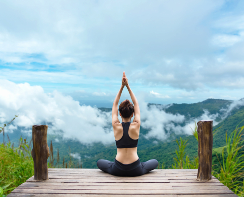 Frau mach Yoga mit Ausblick auf Berge