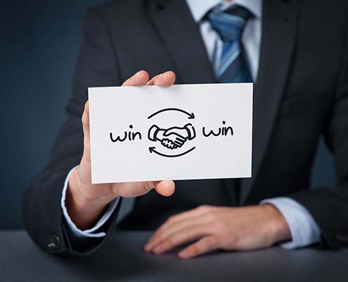 Businessbroker hält Karte mit "Win-win"-Symbol in der Hand